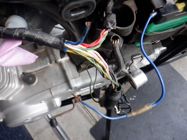 と思ったのも束の間。ご覧の通り古いバイクに「あるアル」です。
ランプが全て作動しなくなるトラブル=振り出しに戻る。
配線内部(メインワイヤハーネス)のマイナス端子を接続してある部分が軽く引っ張ったら「抜けました!!」
てことでこの部分を接続したらOKです。
でも、メインフレームのヘッドパイプ部分のメインハーネス取り回しは今にもちぎれそうなくらいにインシュロックで締め付けて脱落防止してありますが、間違いなく断線箇所の「候補」です。
よりスタンダード位置に近づいた取り回しに変更します
。