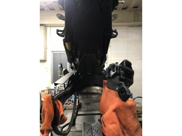 リフトアップして車体を安定させ、前後ホイールを取り外している工程です。作業スペース確保と安全性確保のため、しっかり固定した状態で分解作業を行っています。